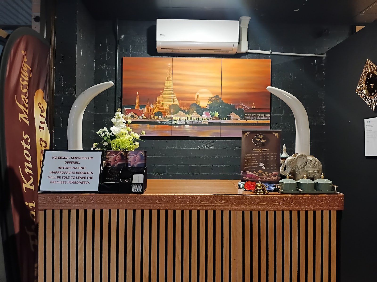 The reception counter with a Thai temple painting and carved tusks